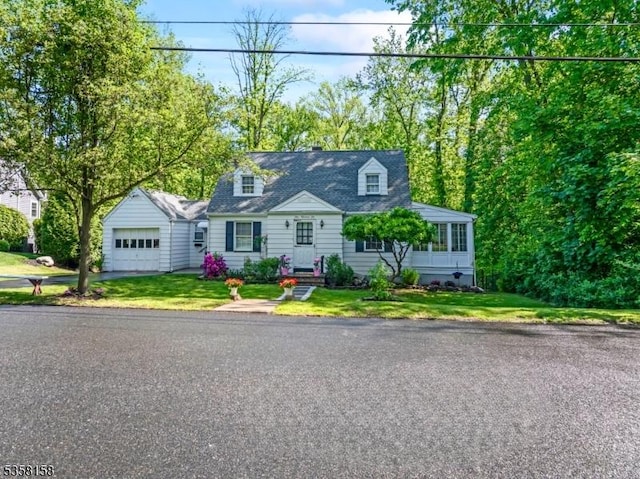 new england style home with a garage, a front yard, and a chimney