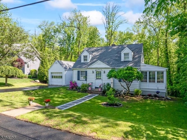 new england style home with a front lawn, driveway, and an attached garage