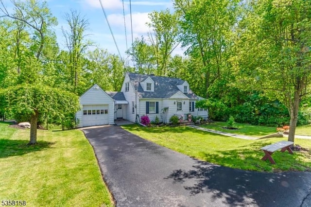 cape cod home featuring asphalt driveway, an attached garage, and a front lawn