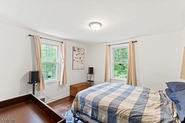 bedroom featuring dark wood-style floors and baseboards