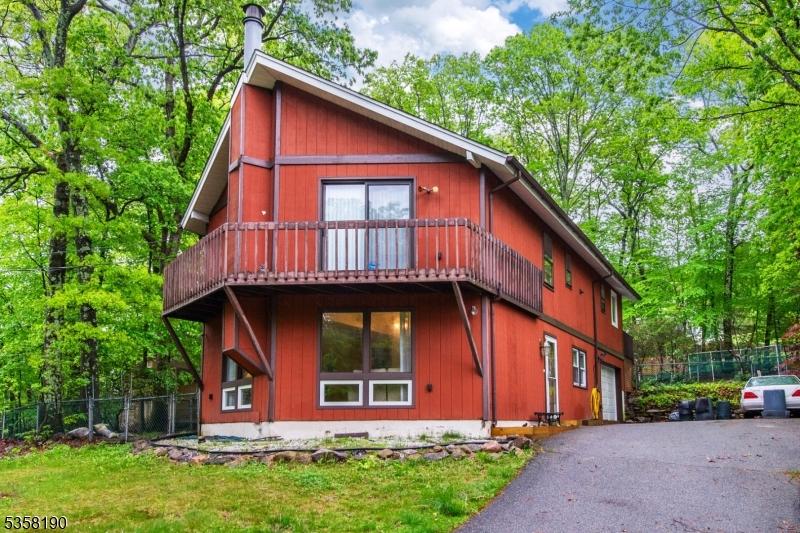 1012 Green Pond Rd, Rockaway Twp, NJ 07435 - rustic home with fence, driveway, an attached garage, and a wooden deck