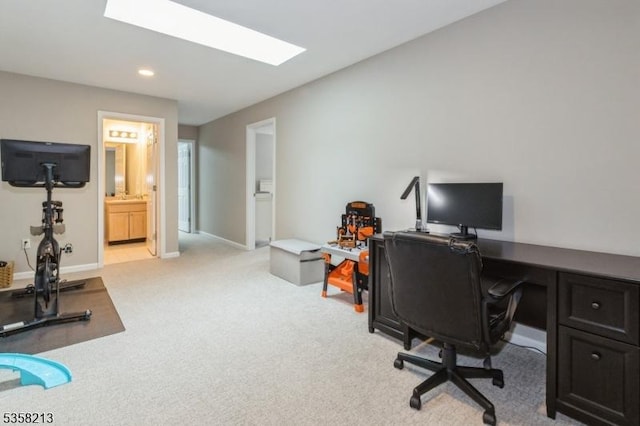 office space featuring light colored carpet, a skylight, recessed lighting, and baseboards