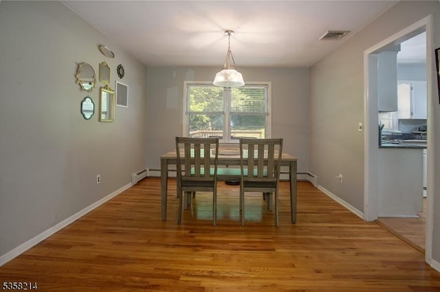 dining area with light wood-style flooring, baseboards, and baseboard heating