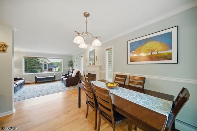 63 Cedar Lk W, Denville Twp, NJ 07834 - dining room with a chandelier, baseboard heating, light wood-style floors, ornamental molding, and a tile fireplace