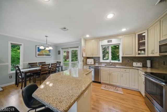 63 Cedar Lk W, Denville Twp, NJ 07834 - kitchen featuring appliances with stainless steel finishes, a sink, cream cabinets, crown molding, and healthy amount of natural light