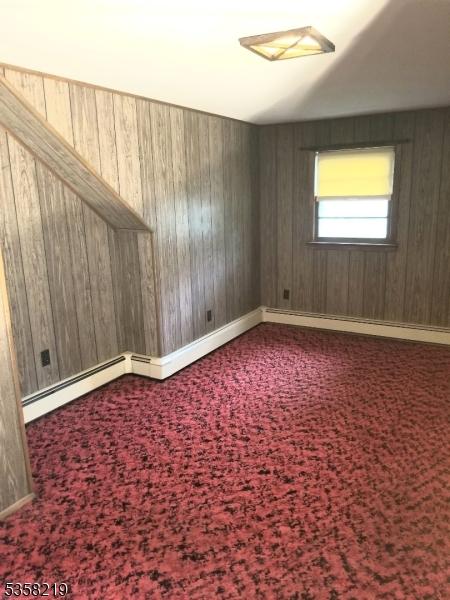 18 Cray Ter, Fanwood Boro, NJ 07023 - carpeted empty room featuring wooden walls, baseboard heating, and baseboards