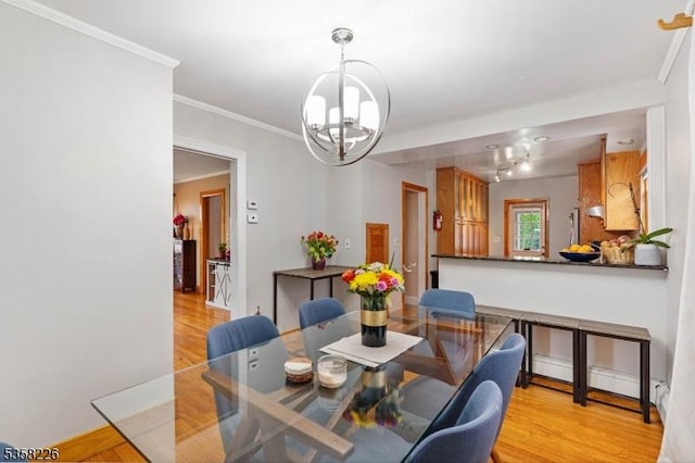 dining space with a chandelier, light wood finished floors, and ornamental molding
