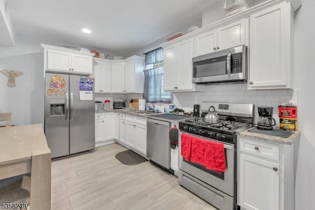227 N Center St, City Of Orange Twp, NJ 07050 - kitchen featuring appliances with stainless steel finishes, decorative backsplash, white cabinetry, and recessed lighting