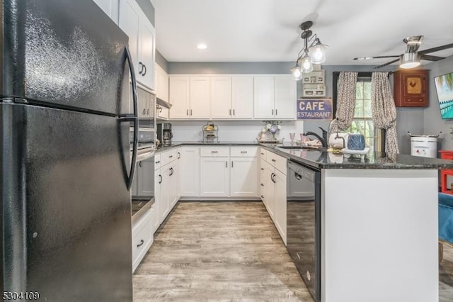 kitchen featuring black appliances, a sink, a peninsula, light wood finished floors, and white cabinetry