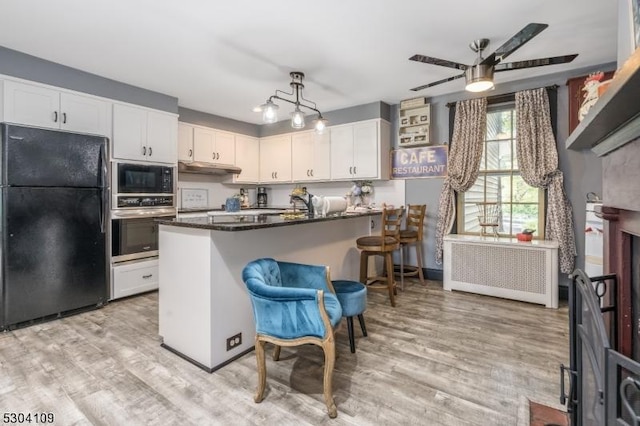 kitchen with black appliances, white cabinets, ceiling fan, and light wood-style floors