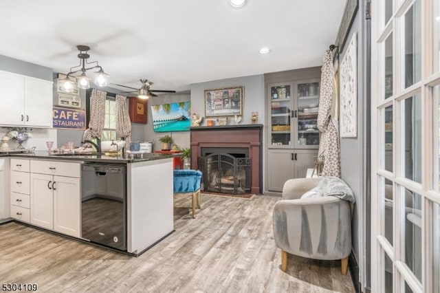 kitchen with dishwasher, dark countertops, white cabinets, light wood-style flooring, and recessed lighting