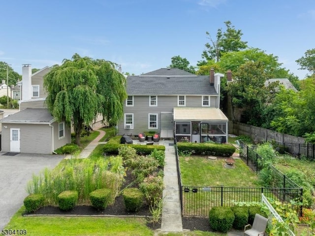 rear view of property featuring a sunroom and a chimney