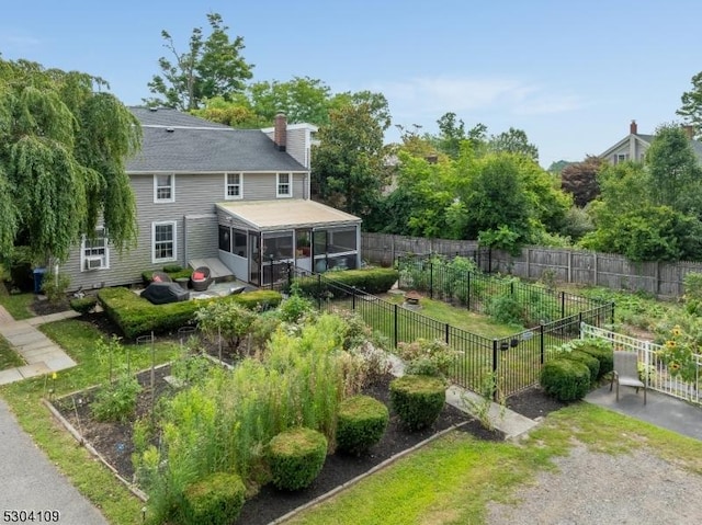 view of yard featuring a vegetable garden and a sunroom