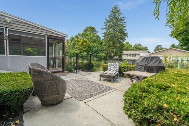 view of patio featuring fence and a sunroom