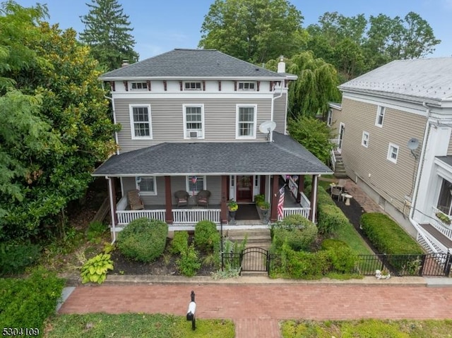view of front facade featuring a porch, a fenced front yard, a gate, and roof with shingles