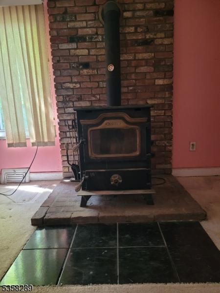 68 Route31, Oxford Twp, NJ 07863 - detailed view of a wood stove and baseboards