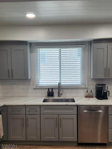 kitchen featuring dishwasher, gray cabinets, a sink, and recessed lighting