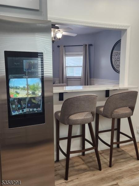 dining space with light wood-style flooring and ceiling fan