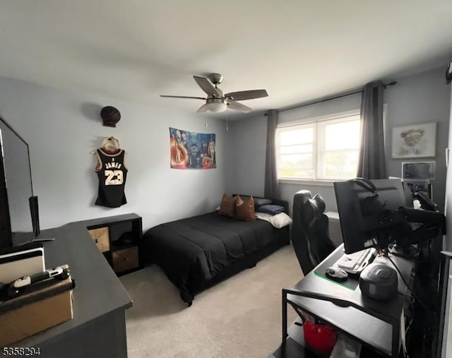 bedroom with light carpet, a desk, and a ceiling fan
