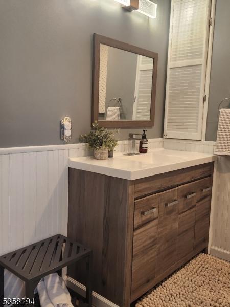 bathroom featuring a wainscoted wall and vanity