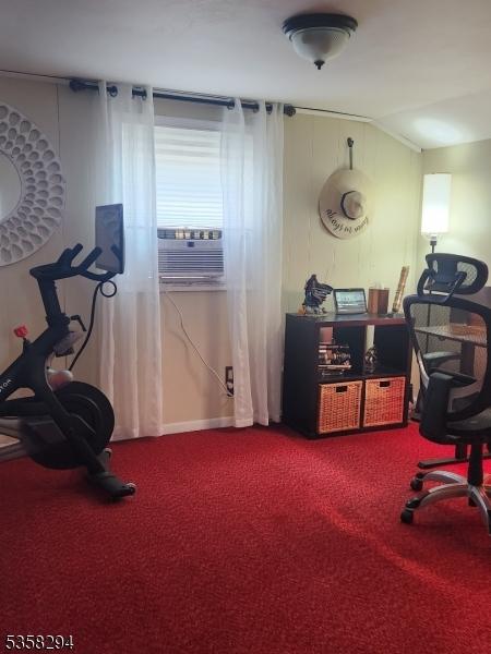 carpeted office featuring cooling unit and vaulted ceiling