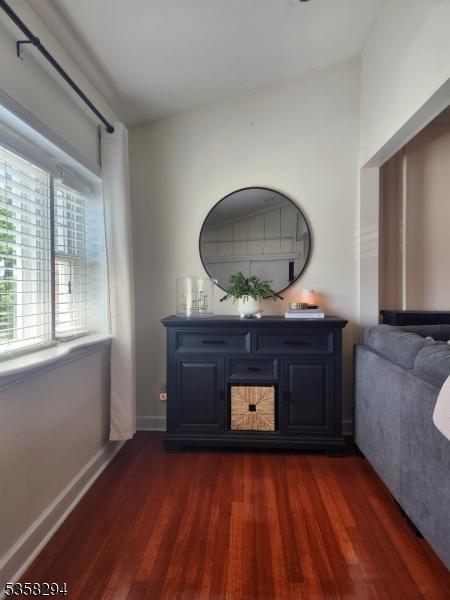 living room featuring dark wood-style flooring and baseboards