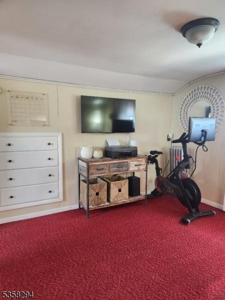 exercise room with dark colored carpet and baseboards
