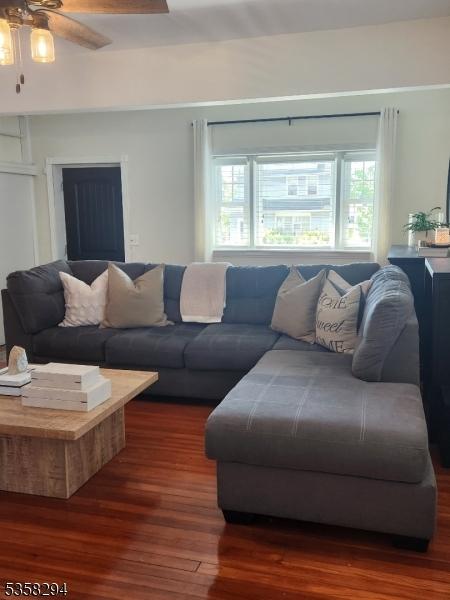 living room with wood finished floors and a ceiling fan