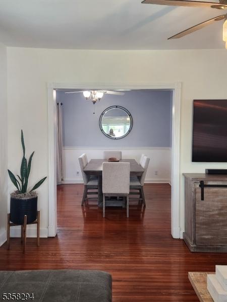 dining room featuring wood finished floors, ceiling fan, and baseboards