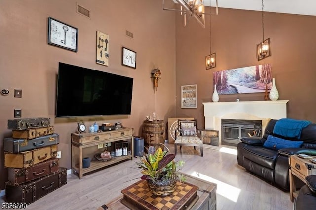 67 Brookwood Rd, Byram Twp, NJ 07874 - living area featuring wood finished floors, a towering ceiling, and a glass covered fireplace