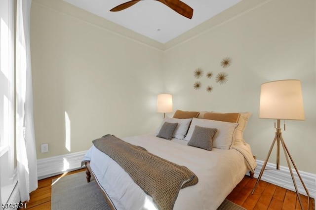 bedroom featuring wood-type flooring, a ceiling fan, and baseboards