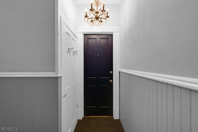 doorway featuring wainscoting and a chandelier