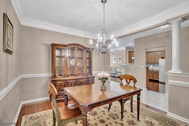2303 Ambassador Ct Unit 2303, Franklin Twp, NJ 08873 - dining area with decorative columns, light wood-style floors, crown molding, a chandelier, and baseboards
