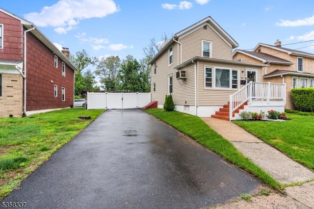 view of front of property featuring a gate and a wall mounted AC