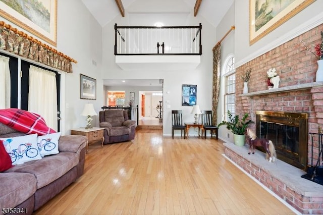 45 Wagner Ln, Hillsborough Twp, NJ 08844 - living room featuring high vaulted ceiling, wood-type flooring, beamed ceiling, a brick fireplace, and baseboards