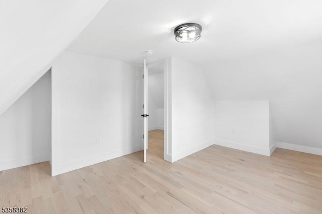bonus room featuring lofted ceiling, wood finished floors, and baseboards