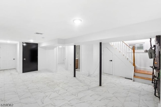 finished basement with light marble finish floors and stairs