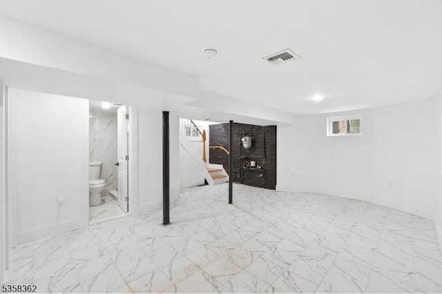 basement with marble look tiles and stairway