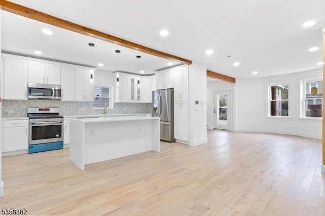 kitchen featuring stainless steel appliances, decorative backsplash, recessed lighting, light countertops, and beam ceiling