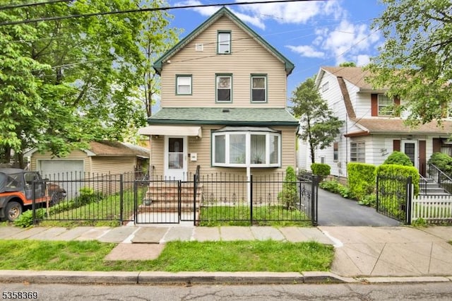 view of front facade featuring a fenced front yard, an outdoor structure, a gate, and a garage