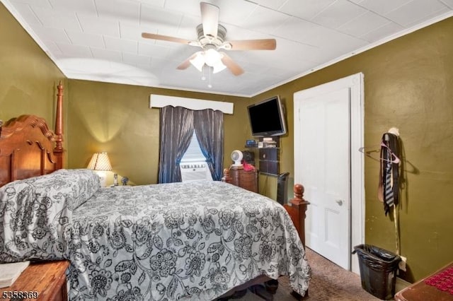 carpeted bedroom featuring ornamental molding and a ceiling fan