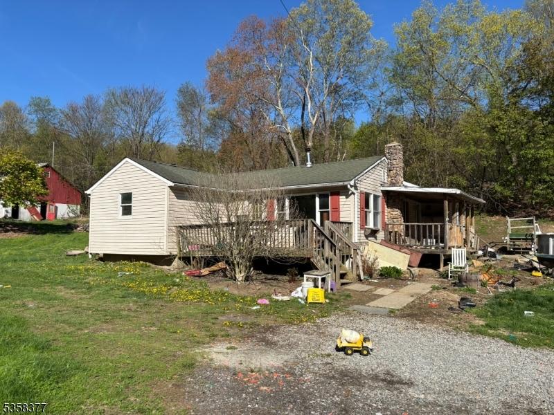 view of front of property with a chimney, a front lawn, and a wooden deck