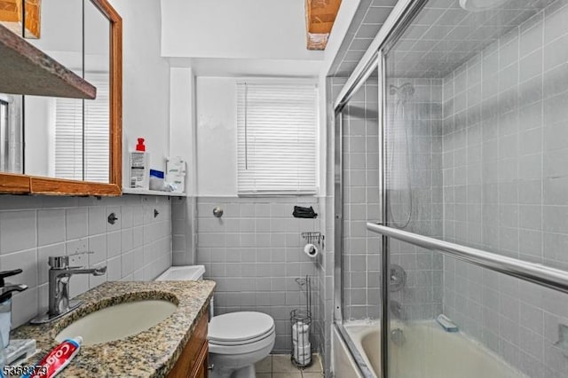 316-318 John St, Elizabeth City, NJ 07202 - full bathroom featuring tile walls, shower / bath combination with glass door, toilet, tile patterned flooring, and vanity