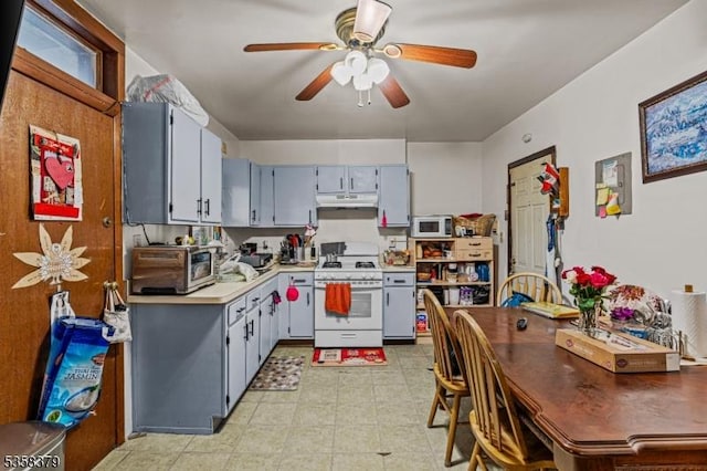 316-318 John St, Elizabeth City, NJ 07202 - kitchen with white appliances, under cabinet range hood, a ceiling fan, light countertops, and gray cabinetry