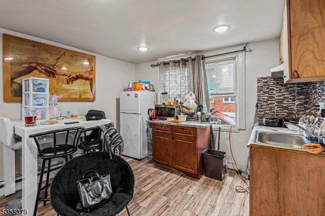 316-318 John St, Elizabeth City, NJ 07202 - kitchen featuring freestanding refrigerator, a sink, stainless steel microwave, brown cabinets, and light wood finished floors