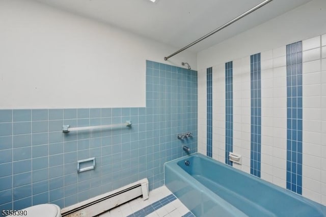 full bathroom with a baseboard radiator, tile walls, tub / shower combination, toilet, and tile patterned floors