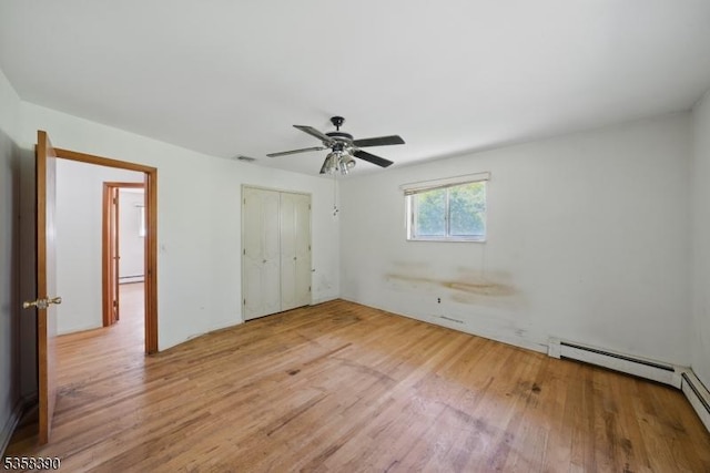 unfurnished bedroom featuring wood finished floors, a closet, ceiling fan, and a baseboard radiator