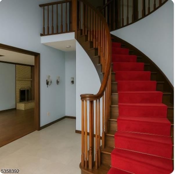 1601 Justin Pl, Mountainside Boro, NJ 07092 - stairs featuring a brick fireplace, tile patterned floors, a towering ceiling, and baseboards