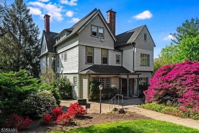 back of house with a chimney and a patio