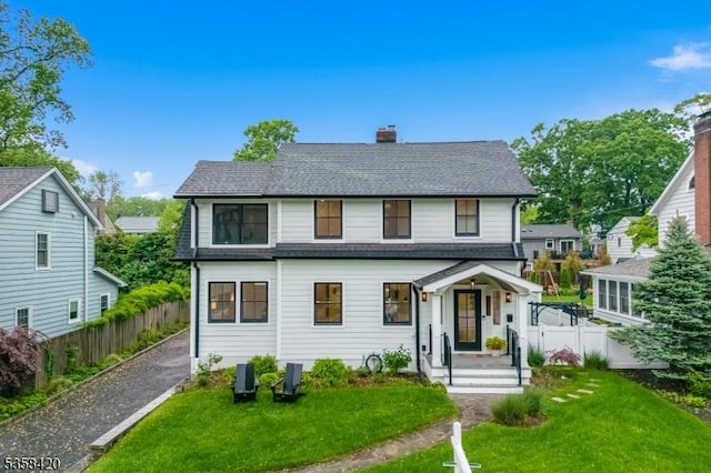 view of front of property with a chimney and a shingled roof